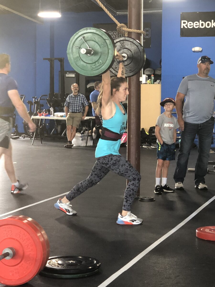 Amanda lifting a barbell overhead in a clean and jerk